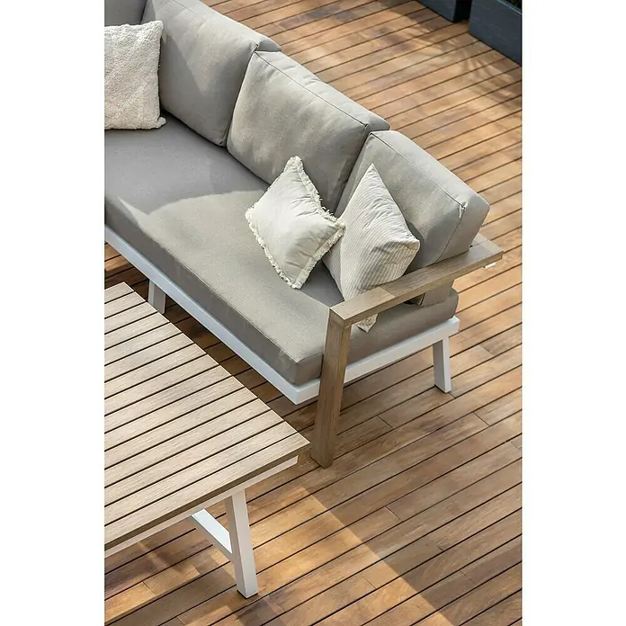 Sunfun Conjunto de muebles Morgana - 4 pzs., Enviro Imitation Wood® / Aluminio, Marrón/Blanco - Primer plano de un sofá gris moderno con detalles blancos y una mesa de centro a juego en un patio de madera.