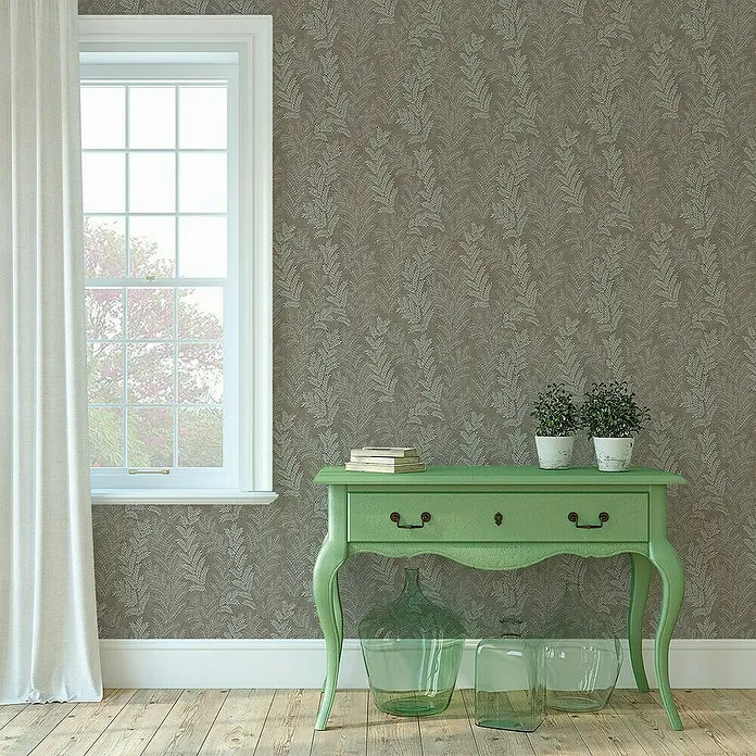 Papel pintado Flor Falguera - Gris/Marrón, 10 x 0,53 m - Mesa consola verde con cajones, plantas y libros, sobre una pared estampada y una ventana.