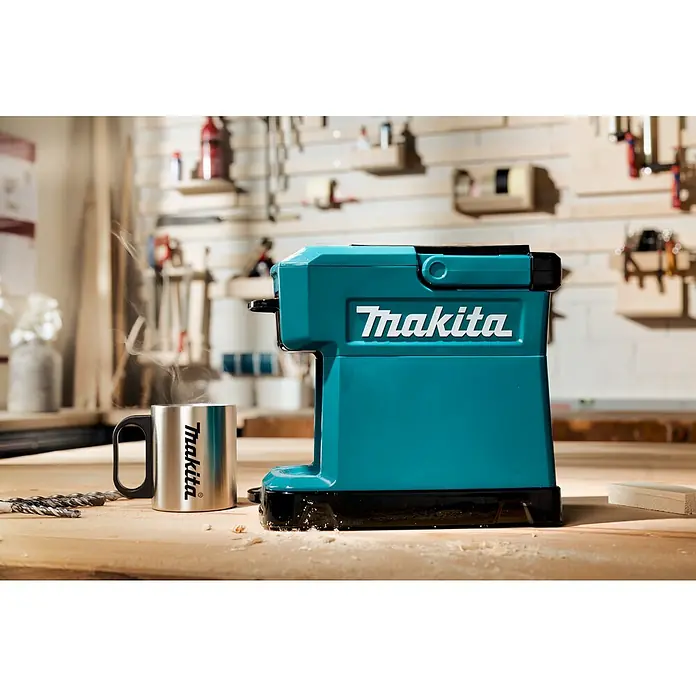 Makita LXT 18V Cafetera a batería DCM501Z - 18 V, Sin batería, Volumen de recipiente: 0,24 l - Cafetera Makita en turquesa y negro con taza a juego en un taller.
