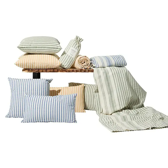 Manta para sofá Ernesta - 150 x 250 cm, Textil, Azul - Varios cojines y ropa de cama a rayas están artísticamente dispuestos en un estante de madera.