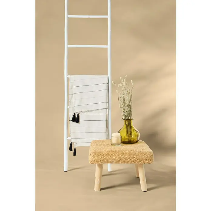 Manta para sofá Damaris - 150 x 250 cm, Textil, Natural - Idea de estilo interior con una escalera blanca, una manta de rayas con borlas y un taburete pequeño con un jarrón amarillo y una vela encima.