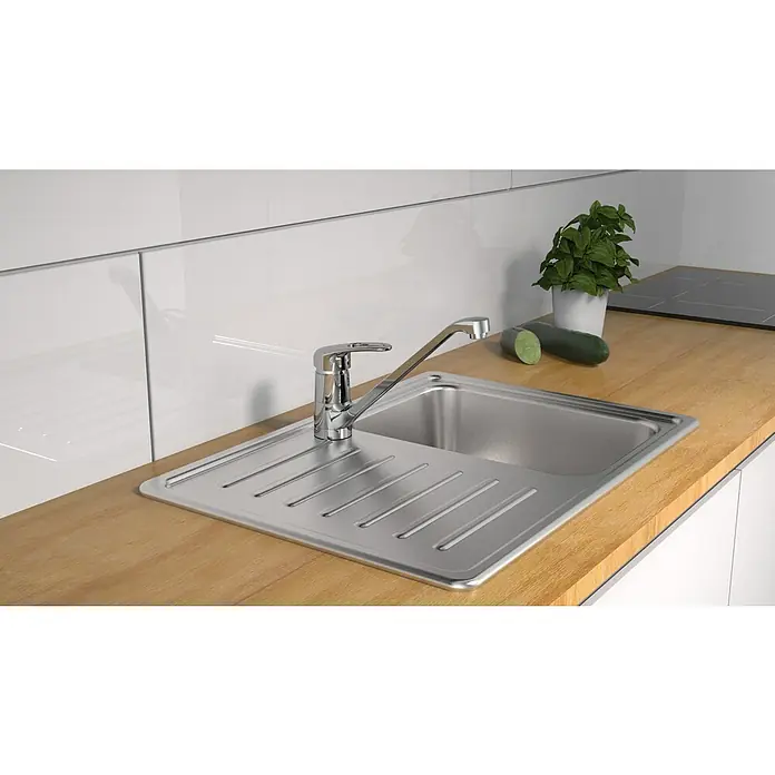 Camargue Spültischarmatur Grande - Niederdruck, Glänzend - Küchenspüle aus Edelstahl mit Abtropffläche und einem Hahn. Die Spüle ist in eine hölzerne Arbeitsplatte eingebaut.