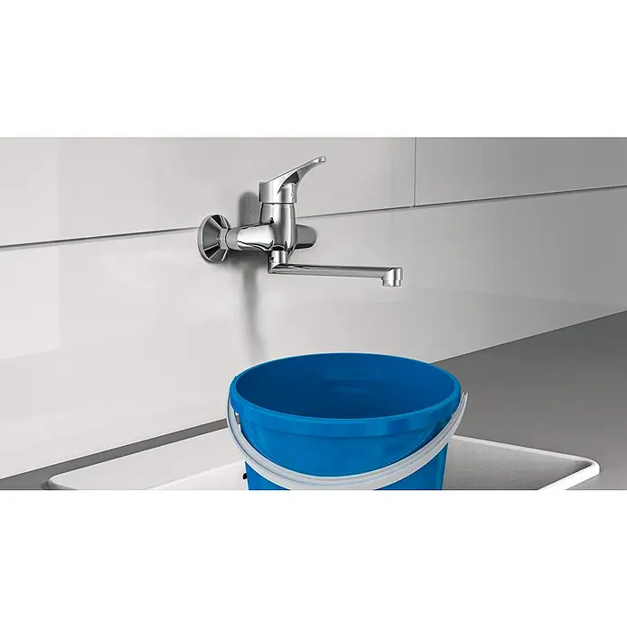 Camargue Spültischarmatur Attica - Chrom, Glänzend, Schwenkbar, Wandmontage - Nahaufnahme eines modernen Chrom-Wasserhahns über einem blauen Eimer, der die Funktionalität und das Design der Armatur hervorhebt.