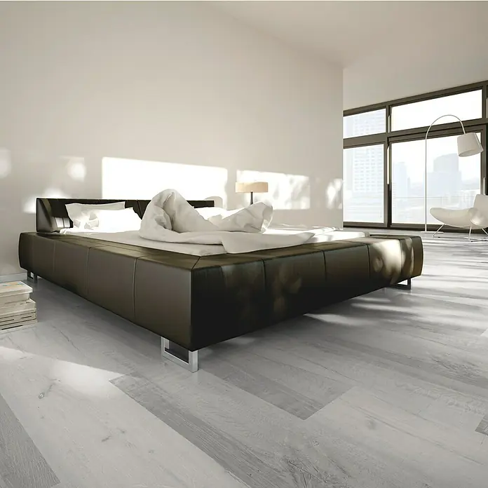 Vinylbodenmuster Sly XXL Dublin Oak - 280 x 160 x 7 mm, Landhausdiele - Großes, modernes Schlafzimmer mit einem luxuriösen, schwarzen Lederbett als Blickfang und hellen Holzboden.