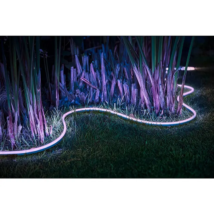 Philips Hue LED-Band Outdoor - Länge: 5 m, Lichtfarbe: RGBW, 37,5 W, 1.600 lm - Beleuchteter flexibler LED-Streifen im Garten, der Pflanzen und Gras mit einem weichen, diffusen Licht hervorhebt.