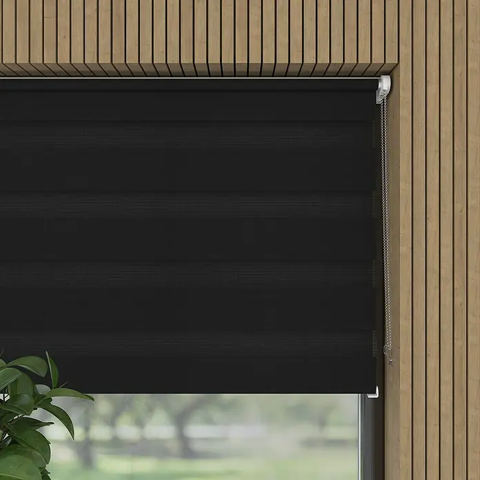 Doppelrollo BasicB x H: 75 x 150 cm, Schwarz - Eine Nahaufnahme einer schwarzen Doppelrollo-Fensterabdeckung mit einem Kettenzug vor einem holzgetäfelten Hintergrund.