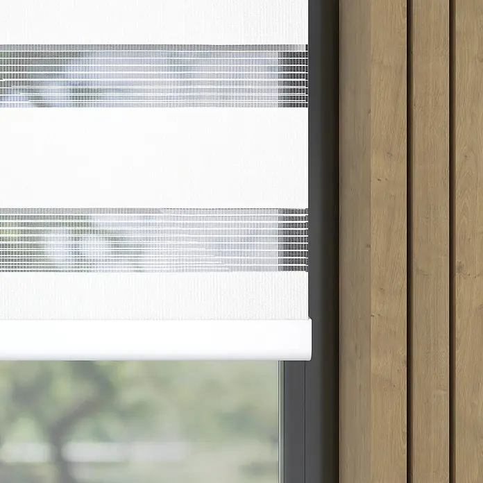 Doppelrollo BasicB x H: 45 x 150 cm, Weiß - Nahaufnahme einer weißen Doppelrollo mit abwechselnd transparenten und undurchsichtigen horizontalen Streifen vor einem Fenster.