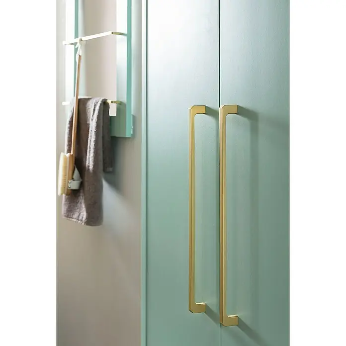 Schildmeyer Sarah Highboard - 46,2 x 30 x 154,7 cm, Mint, Matt - Nahaufnahme von zwei eleganten, goldenen Schrankgriffen an einer mintgrünen Schranktür, die ein modernes und stilvolles Badezimmerdesign hervorhebt.