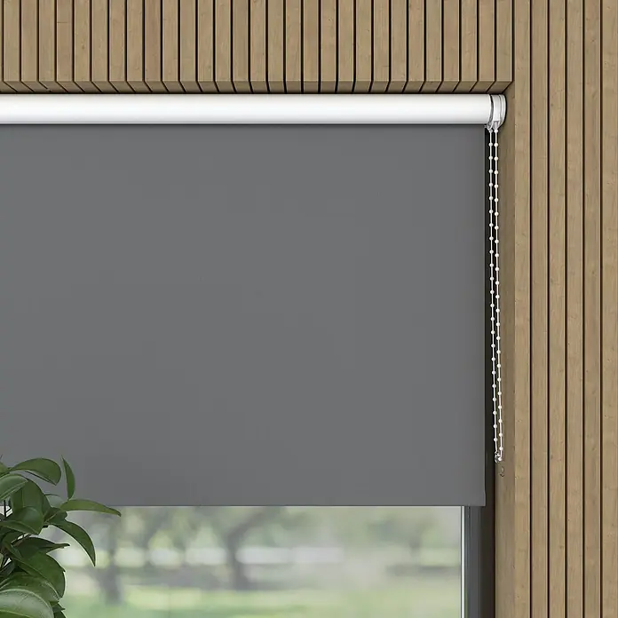 Expo Ambiente Verdunkelungsrollo - B x H: 80 x 190 cm, Grau, Uni - Ein graues Rollo bedeckt ein Fenster, das vor einem Hintergrund aus Holzpaneelen und Pflanzen für Privatsphäre sorgt.