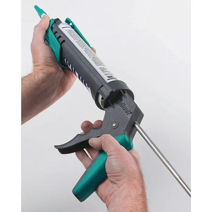 Wolfcraft Pistola de silicona MG 200 - Apto para: Silicona y cartuchos - Primer plano de una pistola de calafateo Wolfcraft sostenida por una persona, lista para ser utilizada, sobre un fondo claro.