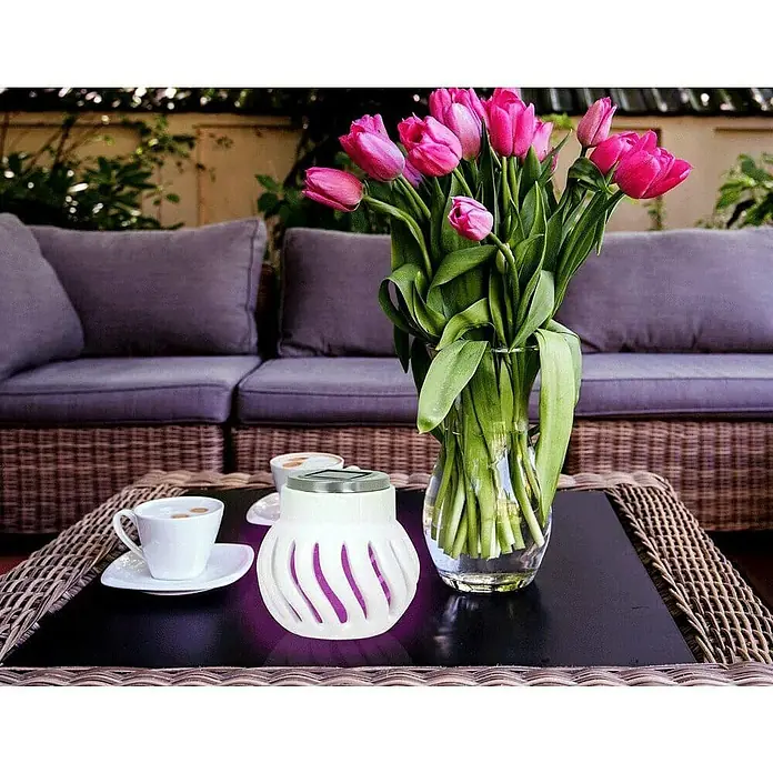 Farolillo antimosquitos solar Oriental - 12 V - Primer plano de una mesa de jardín con tulipanes, tazas y una luz solar decorativa, creando un ambiente acogedor.