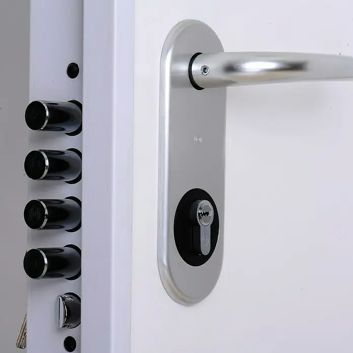 SegureStil Puerta de entrada exterior VH500 Serie V - 90 x 207 cm, Izquierda, Blanco, Acorazada - Primer plano de una puerta con una moderna cerradura de seguridad y manija plateada. La puerta es blanca y la cerradura tiene múltiples puntos de bloqueo.