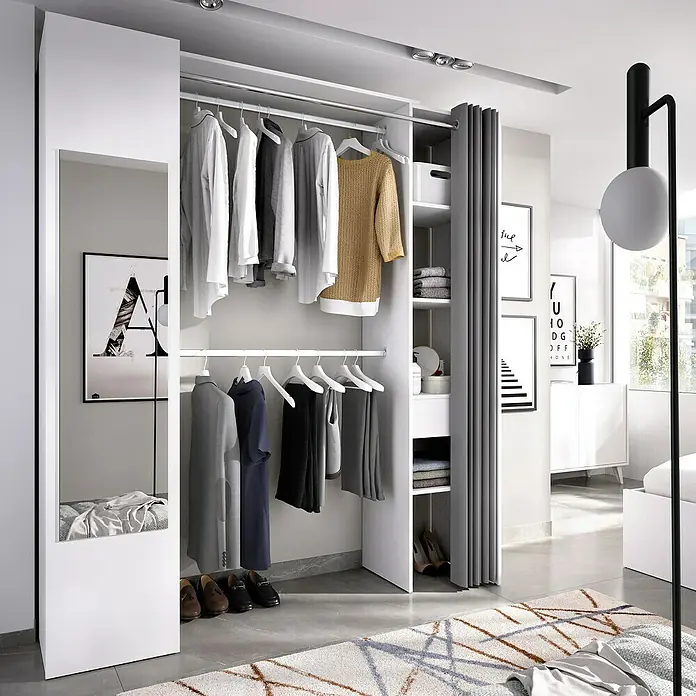 Dekit Armario para ropa Suit - L x An x Al: 52 x 177 x 205 cm, Blanco, Melamina - Un moderno armario blanco que muestra una variedad de prendas de vestir colgadas en perchas con estantes de almacenamiento adicionales para accesorios.