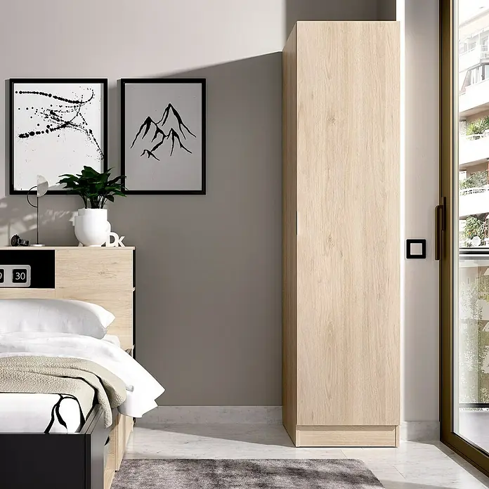 Dekit Armario para ropa Essen - L x An x Al: 52 x 41 x 184 cm, Natural - Un armario de madera clara se alza junto a una ventana en un dormitorio moderno, con cama y arte en la pared.