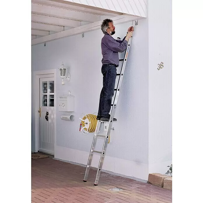 Krause Monto Escalera de apoyo - Número de peldaños: 9 ud., Altura de trabajo: 3,6 m, Carga soportada: 150 kg, Aluminio - Hombre en una escalera multifunción de aluminio plateado trabajando en un techo exterior.