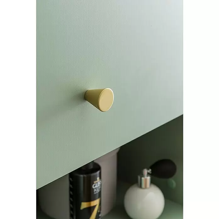 Schildmeyer Ando Highboard - 40,3 x 33,05 x 114,4 cm, Pistazie, Matt - Messingfarbener konischer Knopf an einem salbeigrünen Schrank, darunter verschwommene Toilettenartikel.
