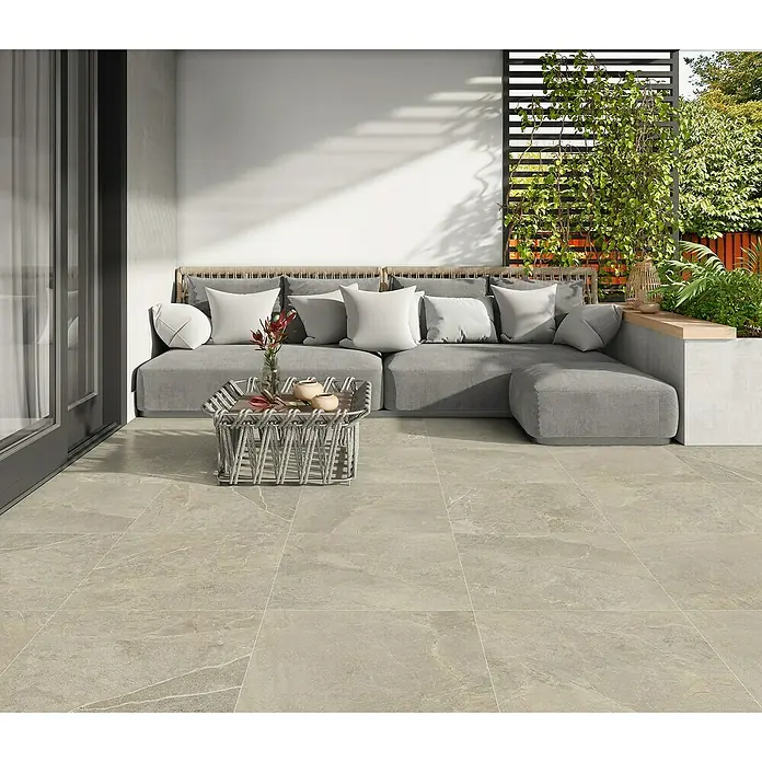 Halcón Pavimento porcelánico Tempo - 60,5 x 60,5 cm, Nature, Mate, Clase 3 Antideslizante - Un patio moderno con baldosas de suelo beige que crean un ambiente cálido y acogedor. Las baldosas complementan perfectamente la zona de estar.
