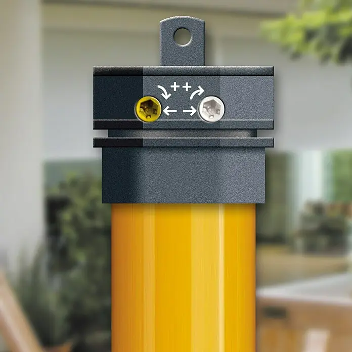 Schellenberg Motor tubular Mini Standard - Fuerza de tracción: 6 kg - Primer plano de un bolardo amarillo con una cabeza gris, mostrando dos tornillos y flechas direccionales, ideal para seguridad exterior.