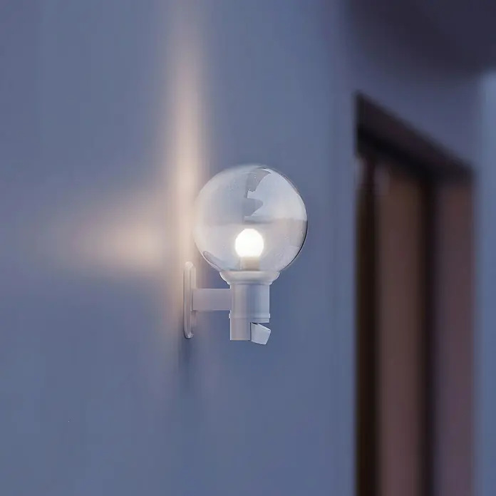Steinel Sensor-Außenleuchte L 560 S weiß - 60 W, 243 x 215 x 368 mm, Weiß, IP44 - Nahaufnahme einer weißen Außenwandleuchte mit kugelförmigem Lampenschirm, die ein sanftes Licht ausstrahlt.\n