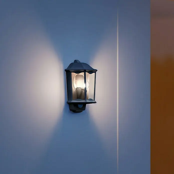 Steinel Sensor-Außenleuchte L 190 S schwarz - 100 W, L x B x H: 147 x 217 x 335 mm, Schwarz - Nahaufnahme einer eleganten Außenwandleuchte, die ein warmes Licht ausstrahlt und eine einladende Atmosphäre schafft.