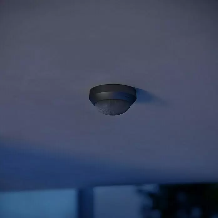 Steinel Bewegungsmelder IS 360-3 schwarz - Reichweite Sensor: 12 m, Schwarz, Erfassungswinkel Sensor: 360 ° - Dunkelgrauer Deckenbewegungsmelder mit transluzenter Kuppel an einer hellgrauen Decke.