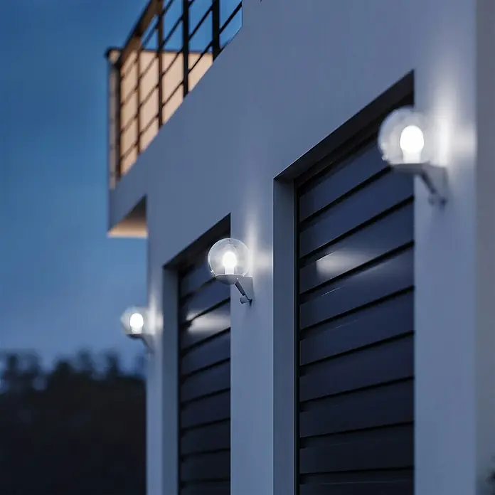 Steinel Sensor-Außenleuchte L 585 S weiß - 60 W, 22,8 x 21,5 x 30,7 cm, Weiß, IP44 - Diese Aufnahme zeigt eine moderne Außenbeleuchtung mit kugelförmigen Lampen, die an einer Hauswand montiert sind.