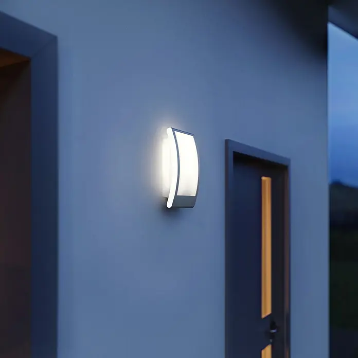 Steinel Außenwandleuchte L 22 anthrazit60 W, 8,1 x 16,2 x 28 cm, Anthrazit, IP44 - Elegante Außenwandleuchte mit sanftem Lichtschein neben einer Haustür. Modernes Design für den Eingangsbereich.