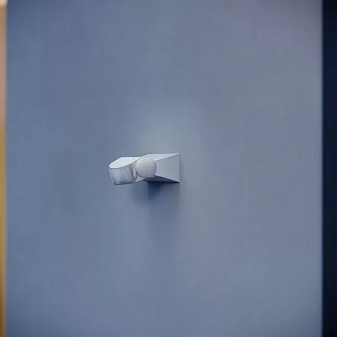 Steinel Sensor de movimiento IS 1 - Alcance sensor: 10 m, Blanco, Ángulo de detección sensor: 120 °, L x An x Al: 120 x 80 x 50 mm - Sensor de movimiento blanco montado en una pared.