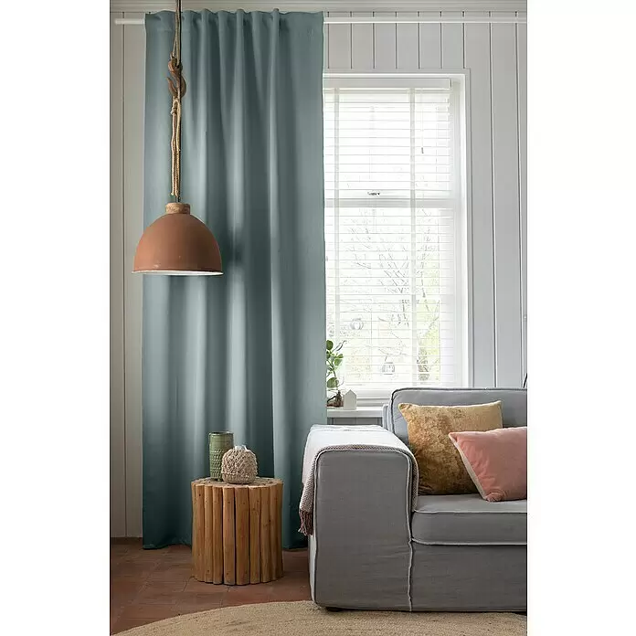 Elbersdrucke Verdunkelungsvorhang Midnight - 140 x 255 cm, 100 % Polyester, Mint - Salbeigrüner Plissee-Vorhang hängt an einer weißen Stange, der ein Fenster in einem hellen Wohnzimmer teilweise verdeckt.