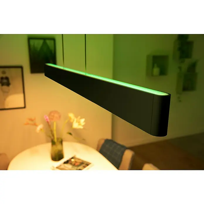 Philips Hue LED-Pendelleuchte White and Color Ambience Ensis - 79 W, L x B x H: 129,9 x 4 x 157 cm, Schwarz, RGBW - Stilvolle Philips Hue Pendelleuchte in Schwarz mit grüner Akzentbeleuchtung über einem Esstisch.