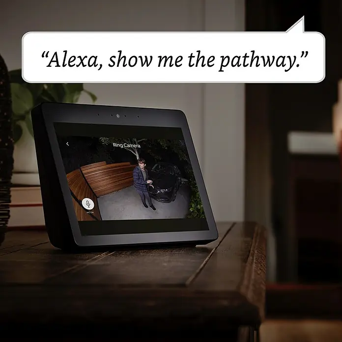 Ring Überwachungskamera Spotlight Cam Plus Plugin - Netzbetrieben, 1.080 Pixel (Full HD), Schwarz, B x H: 7,6 x 12,6 cm, Netzanschluss - Auf einem Tisch steht ein Amazon Echo Show mit der Anzeige einer Ring-Kameraaufnahme. Das Gerät zeigt Live-Überwachung des Eingangsbereichs.