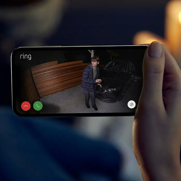 Ring Überwachungskamera Spotlight Cam Plus Plugin - Netzbetrieben, 1.080 Pixel (Full HD), Schwarz, B x H: 7,6 x 12,6 cm, Netzanschluss - Nahaufnahme eines Smartphones mit der Ring-App, die einen Mann vor einem Auto zeigt, für Sicherheit und Überwachung.