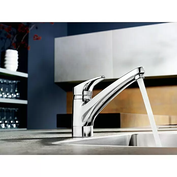 Hansa Mix Spültischarmatur - Niederdruck, Chrom, Glänzend - Verchromte Küchenarmatur mit fließendem Wasser in einer Edelstahlspüle in moderner Küche.