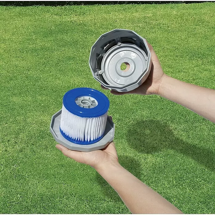 Bestway Filterkartusche Lay-Z-Spa - 10,6 cm - Hände halten ein graues Poolfiltergehäuse und eine weiße Filterkartusche mit blauen Kappen, zeigen Montage oder Austausch.