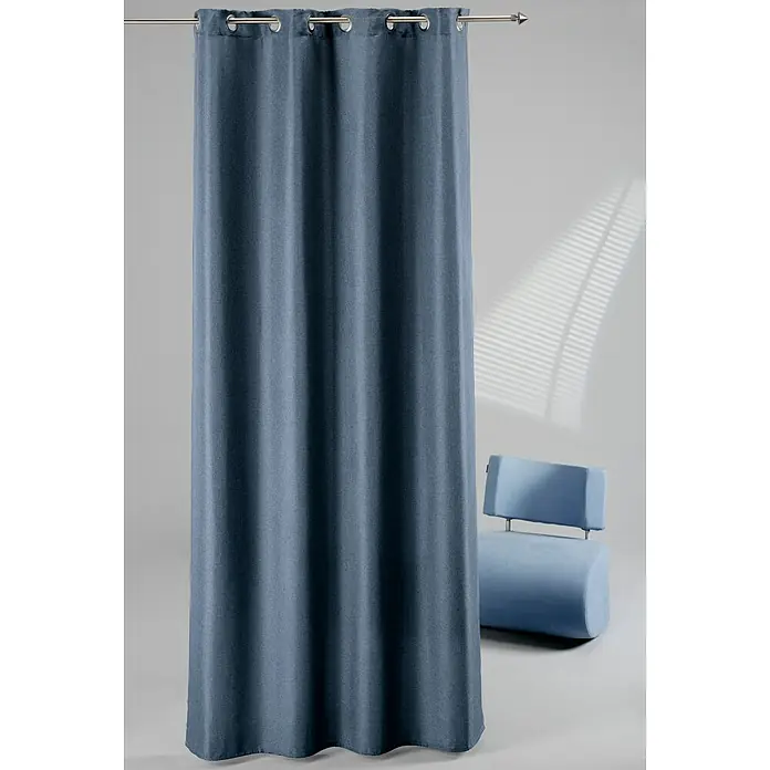 Elbersdrucke Ösenschal Lino - Petrol, 140 x 255 cm, 100 % Polyester - Ein blauer Vorhang mit Metallösen hängt an einer Stange vor einem grauen Hintergrund und einem blauen Sessel.