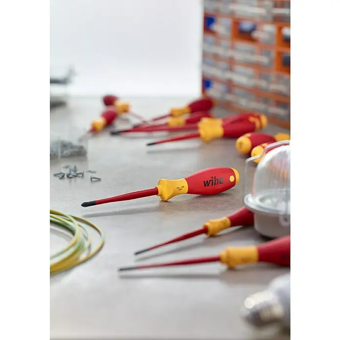 Wiha Elektriker-Schraubendreher SlimFix VDE - PH 2, Klingenlänge: 80 mm - Verschiedene Wiha-Schraubendreher liegen auf einer Werkbank und warten auf ihren Einsatz. Perfekt für Profis, die Wert auf Qualität legen.