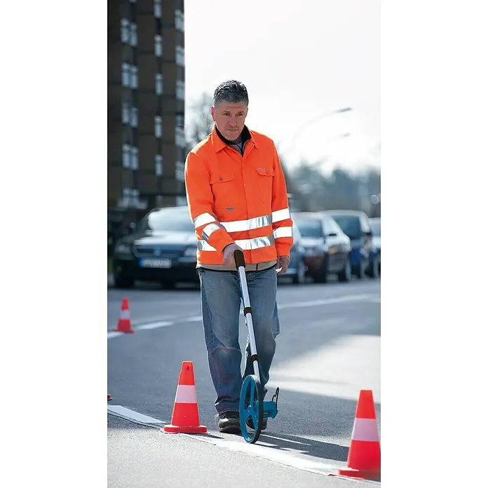 Bosch Professional Messrad GWM 32 - Messbereich: Max. 9999,99 m, Messgenauigkeit: 10 cm/100 m - Mann mit orangefarbener Jacke und Messrad. Das blaue Messrad wird zur genauen Messung der Straßenmarkierung verwendet.