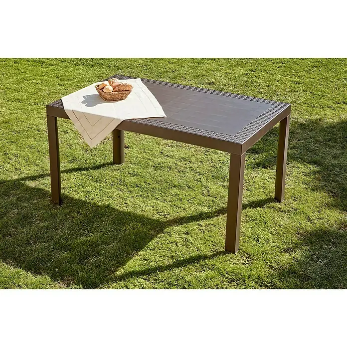 Mesa de jardín Dream - L x An x Al: 140 x 85 x 73 cm, Polipropileno, Wengué - La imagen muestra una mesa de comedor rectangular de exterior con una cesta de pan en un césped, ideal para comidas al aire libre.