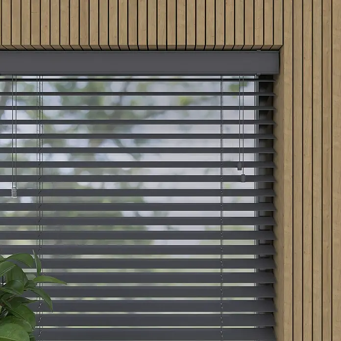 Jalousie - B x H: 180 x 175 cm, Anthrazit, Kunststoff - Nahaufnahme von grauen Jalousien, die vor einem Fenster mit unscharfem Hintergrund hängen, ergänzt durch eine Holzvertäfelung.