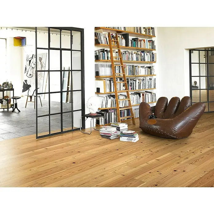 Parador Parkett Classic 3060 - Lärche Naturöl plus, Landhausdiele, 2.200 x 185 x 13 mm - Heller Holzboden mit breiten Dielen in einem stilvollen Raum mit Bücherregal und ungewöhnlichem Sessel. Warme und natürliche Optik.
