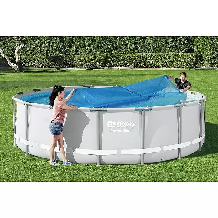Bestway Solarabdeckplane - Durchmesser: 462 cm, Blau - Zwei Personen bedecken einen Bestway Power Steel Aufstellpool mit einer blauen Solarabdeckung.