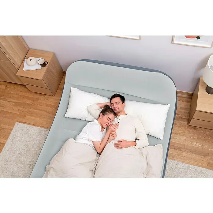 Bestway Luftbett SleekFlow - L x B x H: 226 x 152 x 84 cm, Integrierte Luftpumpe - Ein Luftbett mit integriertem Kopfteil und ein Paar, das darauf schläft. Das Luftbett bietet Komfort und Bequemlichkeit für einen erholsamen Schlaf.