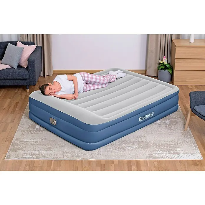 Bestway Luftbett Vento - L x B x H: 203 x 152 x 46 cm, Integrierte Luftpumpe - Eine Frau entspannt auf einer Bestway Luftmatratze, die Komfort und Bequemlichkeit für spontane Übernachtungsgäste bietet.