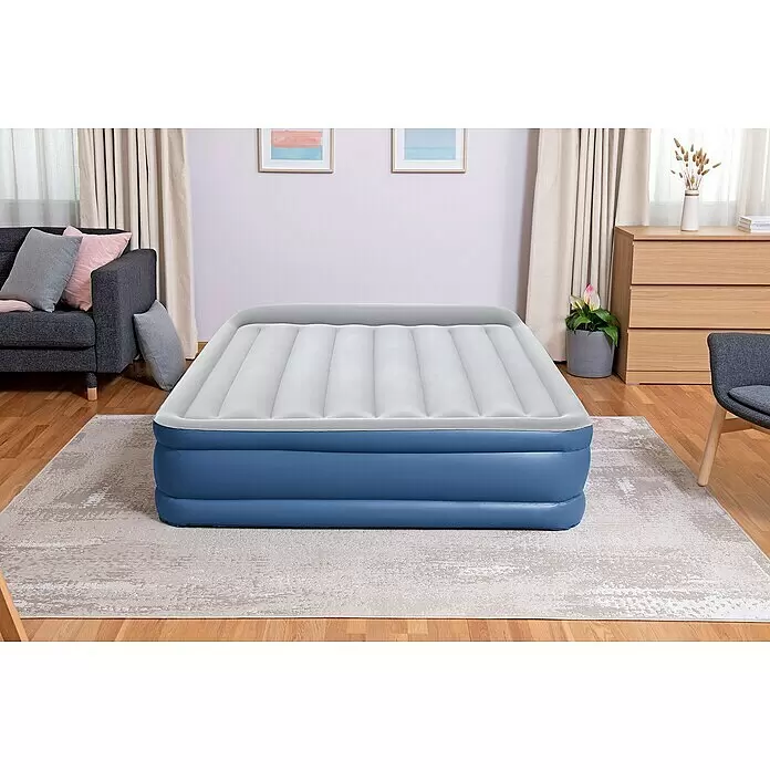 Bestway Luftbett Vento - L x B x H: 203 x 152 x 46 cm, Integrierte Luftpumpe - Blau-weißes aufblasbares Luftbett mit beflockter Oberseite, in einem Wohnzimmer aufgestellt.
