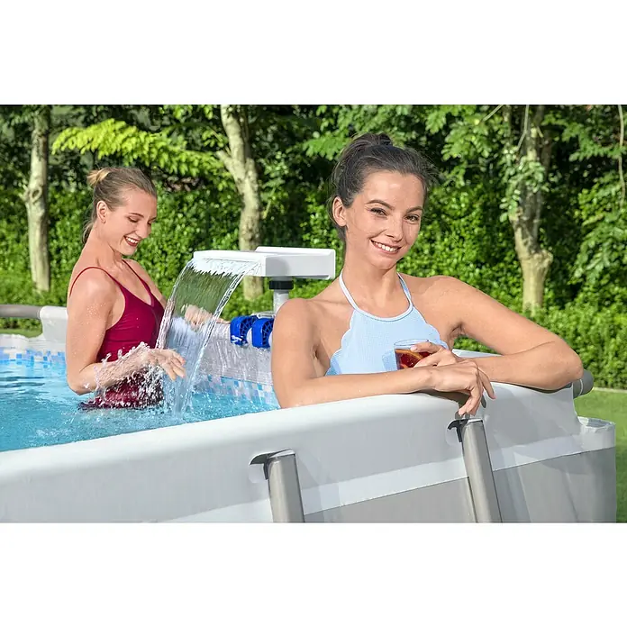 Bestway Schwalldusche - Passend für: Filtersysteme mit einer Durchflussrate von 2.006 l/h - 11.355 l/h, Durchmesser Anschluss: 32 mm - 38 mm - Zwei Frauen genießen das kühlende Wasser in einem Bestway Frame Pool mit Wasserfall an einem sonnigen Tag im Garten.