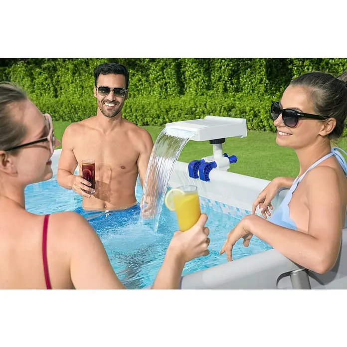 Bestway Schwalldusche - Passend für: Filtersysteme mit einer Durchflussrate von 2.006 l/h - 11.355 l/h, Durchmesser Anschluss: 32 mm - 38 mm - Das Bild zeigt eine Pool-Szene mit einem Wasserfallaufsatz und drei Personen, die Getränke genießen.