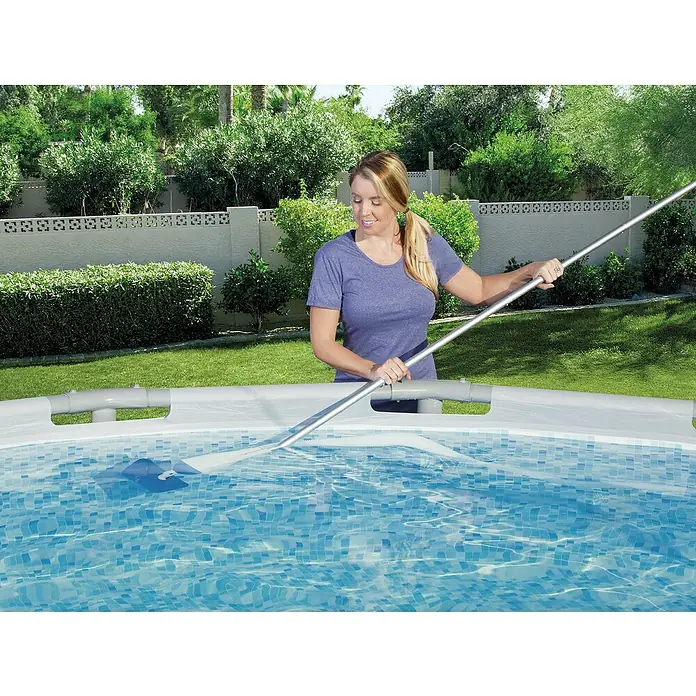 Bestway Flowclear Poolsauger-Set Aquacrawl - Poolreinigung - Eine Frau reinigt mit einer Poolreinigungsstange einen Pool mit blauem Mosaikmuster in einem Garten.
