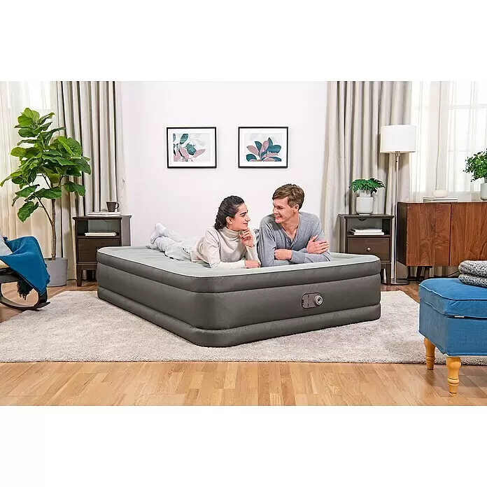Bestway Luftbett Fortech - L x B x H: 203 x 152 x 46 cm, Integrierte Luftpumpe - Dunkelgraue aufblasbare Luftmatratze, auf der zwei Personen bequem in einem Schlafzimmer liegen.