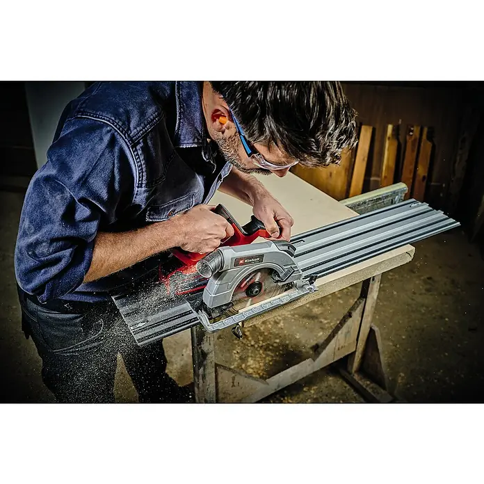 Einhell Professional Power X-Change 18V Akku-Handkreissäge TE-CS 18/190 Li BL-Solo - 18 V, Ohne Akku, Leerlaufdrehzahl: 0 U/min - 3.800 U/min - Ein Mann benutzt eine Einhell Tauchsäge mit Führungsschiene, um ein Holzbrett zu schneiden. Er trägt Schutzkleidung für die Arbeitssicherheit.