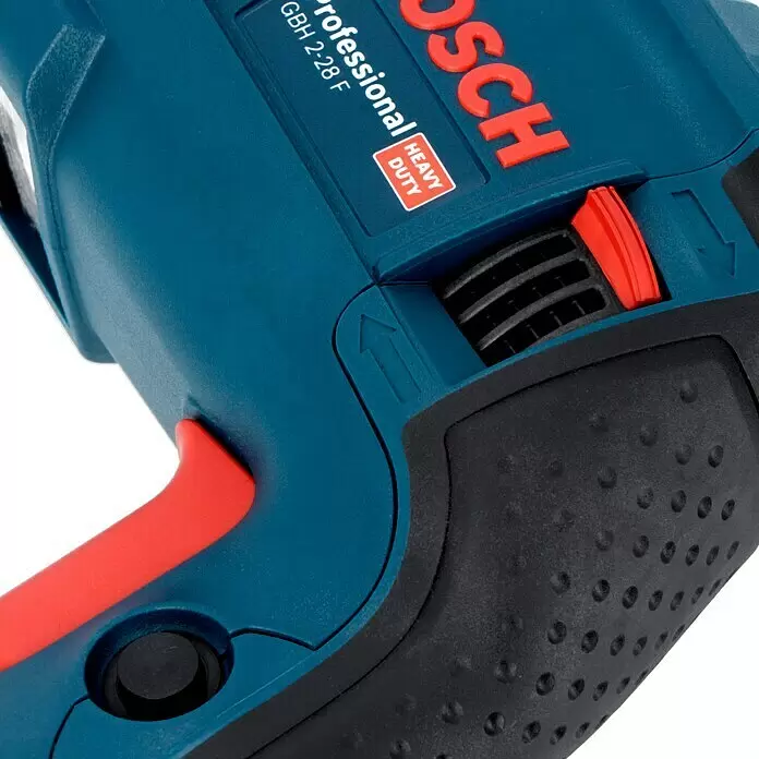 Bosch Professional Kombihammer GBH 2-28 F - 880 W, 3,2 J, SDS-Plus-Aufnahme, Ohne Bohrer & Meißel - Nahaufnahme eines blau-roten Bosch Bohrhammers mit texturiertem schwarzem Griff und rotem Moduswahlschalter.